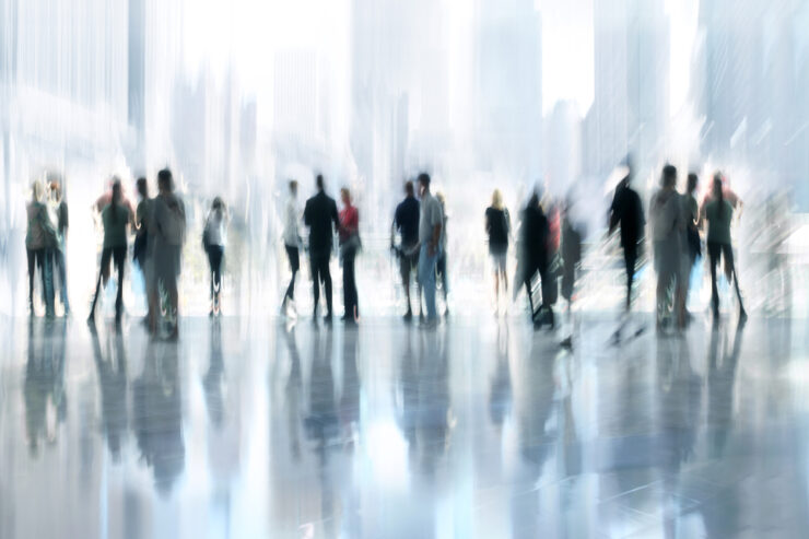 A blurred image of people surrounded by high rise office buildings in a city