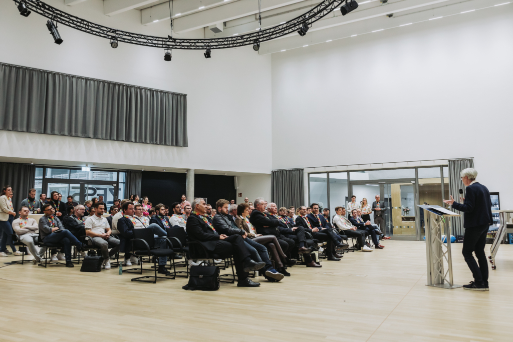A collection of professional people seated listening to a guest speaker in an events space